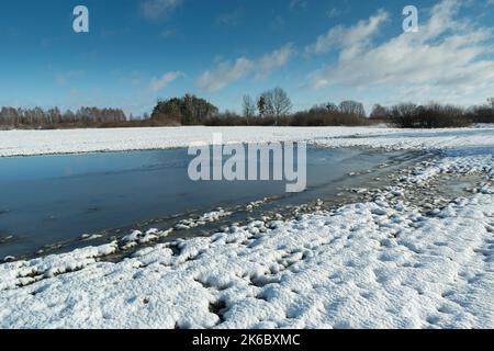 Frozen water and snow on the farmland Stock Photo