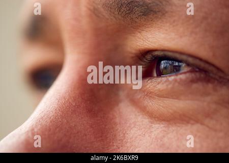 Close Up Of Eyes Of Mature Man Looking Out Of Window Stock Photo