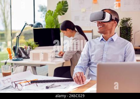 Male Architect In Office Using VR Headset To Design New Building Stock Photo