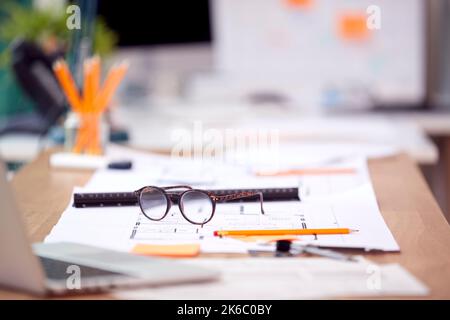 Empty Architects Office With Plans For New Building On Desk Stock Photo