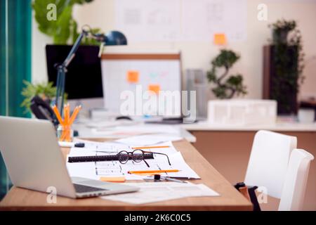 Empty Architects Office With Plans For New Building On Desk Stock Photo