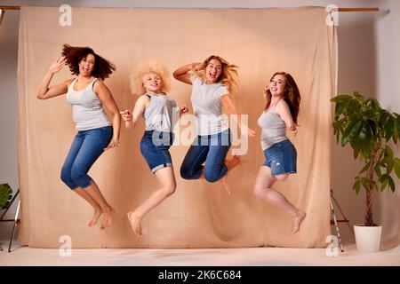 Group Of Diverse Body Positive Casually Dressed Women Friends One With Prosthetic Limb Jumping Stock Photo