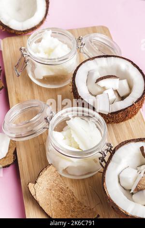 Broken coconut pieces on bright pink background, top view, copy space Stock Photo