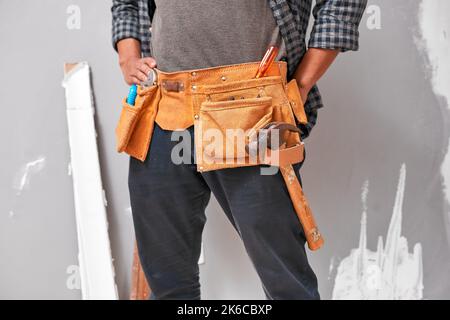 Close up cropped shot of a man wearing a tool belt with tools for home DIY Stock Photo