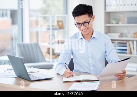 Writing it down helps me remember. a young businessman writing in a notebook at work. Stock Photo