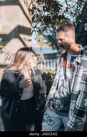 A happy Caucasian male and female couple talking and standing in the garden with sunny trees Stock Photo
