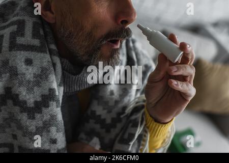 cropped view of sick man with rhinitis using nasal spray,stock image Stock Photo