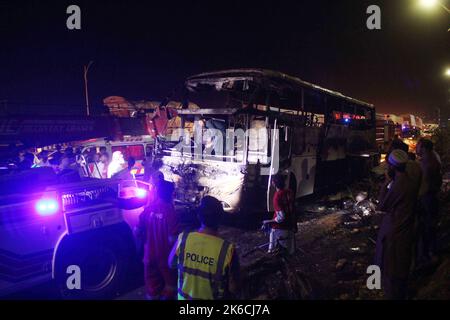 Islamabad, Pakistan. 13th Oct, 2022. Rescuers examine a burnt passenger bus in Jamshoro district of Sindh province, Pakistan, Oct. 13, 2022. At least 18 people, including eight children, were killed and 28 others injured on Wednesday night after a passenger bus caught fire in Pakistan's southern Jamshoro district, police said on Thursday. Credit: Str/Xinhua/Alamy Live News Stock Photo