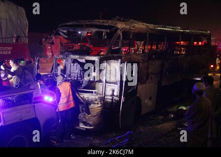 Islamabad, Pakistan. 13th Oct, 2022. Rescuers examine a burnt passenger bus in Jamshoro district of Sindh province, Pakistan, Oct. 13, 2022. At least 18 people, including eight children, were killed and 28 others injured on Wednesday night after a passenger bus caught fire in Pakistan's southern Jamshoro district, police said on Thursday. Credit: Str/Xinhua/Alamy Live News Stock Photo