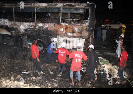 Islamabad, Pakistan. 13th Oct, 2022. Rescuers examine a burnt passenger bus in Jamshoro district of Sindh province, Pakistan, Oct. 13, 2022. At least 18 people, including eight children, were killed and 28 others injured on Wednesday night after a passenger bus caught fire in Pakistan's southern Jamshoro district, police said on Thursday. Credit: Str/Xinhua/Alamy Live News Stock Photo