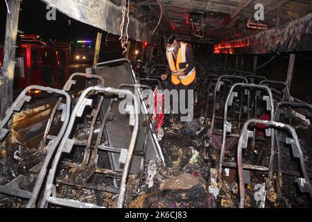 Islamabad, Pakistan. 13th Oct, 2022. A rescuer examines a burnt passenger bus in Jamshoro district of Sindh province, Pakistan, Oct. 13, 2022. At least 18 people, including eight children, were killed and 28 others injured on Wednesday night after a passenger bus caught fire in Pakistan's southern Jamshoro district, police said on Thursday. Credit: Str/Xinhua/Alamy Live News Stock Photo