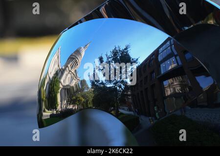 St Paul's Cathedral reflected and distorted in a shiny surface artwork sculpture  near the south entrance. Stock Photo