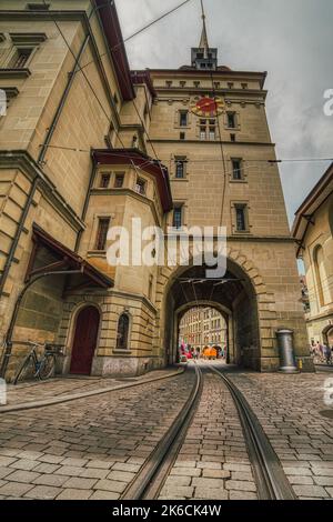 Tram railway tunnel under the baroque tower Kafigturm on a historical cobbled street. Cablecar tracks across the arched medieval steeple in Marktgasse Stock Photo
