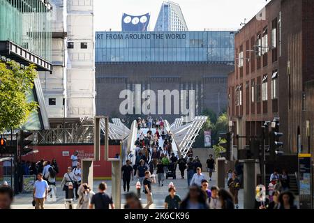 Telephoto lens viewpoint toward Millennium bridge from Knightrider court showing busy crowds of people crossing the bridge towards St Paul's Cathedral Stock Photo