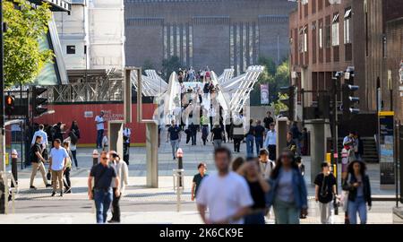 Telephoto lens viewpoint toward Millennium bridge from Knightrider court showing busy crowds of people crossing the bridge towards St Paul's Cathedral Stock Photo