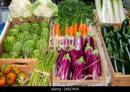 photo of vegetables in the market in wooden crates. tomato, cauliflower, cucumber, carrot, artichoke, eggplant etc. Stock Photo