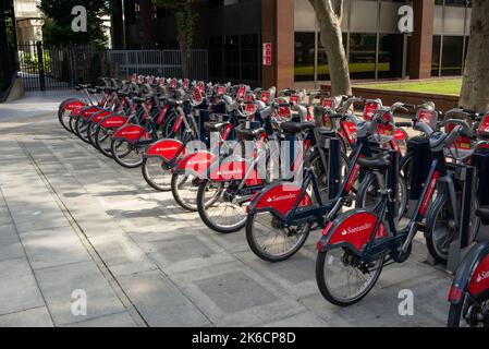 Santander (Boris bikes) rental cycles parked up Lambeth Palace road on a sunny day. Stock Photo