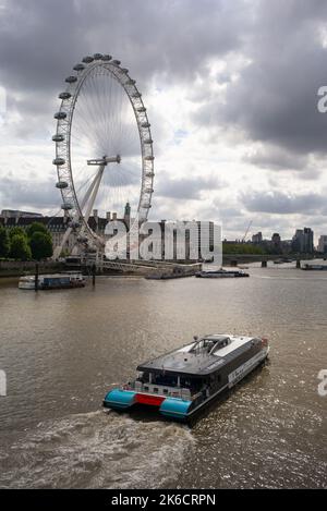 Jupiter Clipper by Thames Clippers Uber Boat passes by The London Eye  travelling towards Westminster Bridge London UK. Stock Photo