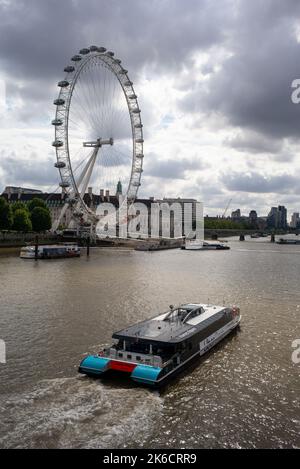 Jupiter Clipper by Thames Clippers Uber Boat passes by The London Eye  travelling towards Westminster Bridge London UK. Stock Photo