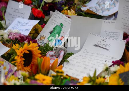 A drawing of the Queen and Paddington bear with corgis sits amongst the tributes and flowers laid for the Late Queen in Green Park London UK. Stock Photo