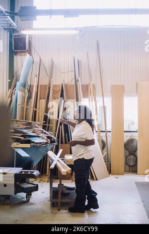 Side view of female carpenter working in workshop Stock Photo