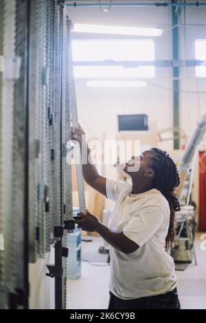 Female carpenter looking up while working in workshop Stock Photo