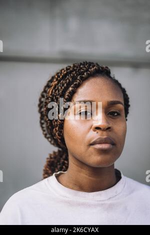Portrait of female construction worker with braided hair against wall Stock Photo
