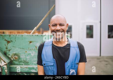 Portrait of happy bald construction worker at site Stock Photo