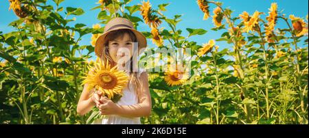 A child in a field of sunflowers. Selective focus. Stock Photo