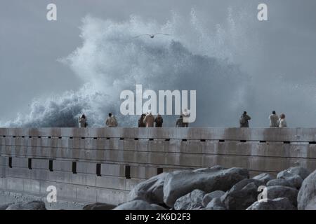 Porto, Portugal - December 31, 2015: People watching storm in the Douro river mouth new pier and beacon. Stock Photo