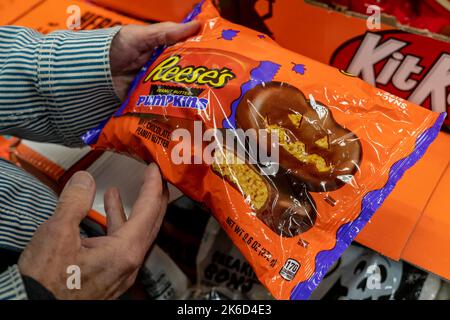 A shopper chooses a bag of Hershey’s Reeses’ Pumpkins Halloween candy in a store in New York on Tuesday, October 11, 2022. The National Retail federation predicts that 2022 consumer spending for Halloween will surpass 2021 levels. (© Richard B. Levine) Stock Photo