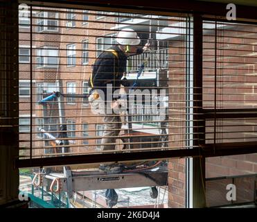 Worker on scaffolding performs city-mandated facade inspection and repair on the exterior of an apartment building in Chelsea in New York on Friday, September 30, 2022,  (© Richard B. Levine) Stock Photo