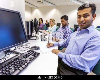 Adult Education: At The Computer. Mature students at work in their college computer suite. From a series of related images on the subject. Stock Photo
