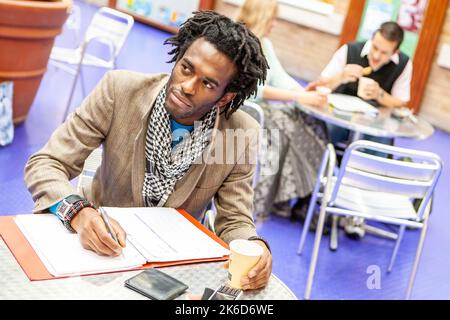 Adult Education: Revision. A student making notes during a break from class. From a series of related images on the subject. Stock Photo