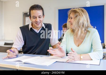 Adult Education: Talking with Teacher. A tutor giving some advice to a mature student. From a series of related images on the subject. Stock Photo