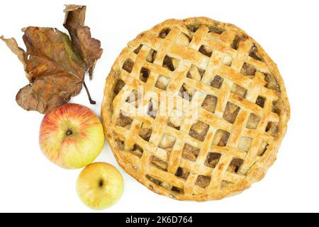 Baked apple pie with trellis decoration on white background. Apples and dried leaves. Copy space. Top view. Stock Photo