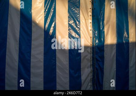 sunlight and shadow on a striped marquee or tent Stock Photo