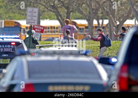 Parkland, USA. 14th Feb, 2018. Students run wth their hands in the air outside of Stoneman Douglas High School in Parkland, Fla. after reports of an active shooter on Wednesday, Feb. 14, 2018. (Photo by John McCall/Sun Sentinel/TNS/Sipa USA) Credit: Sipa USA/Alamy Live News Stock Photo