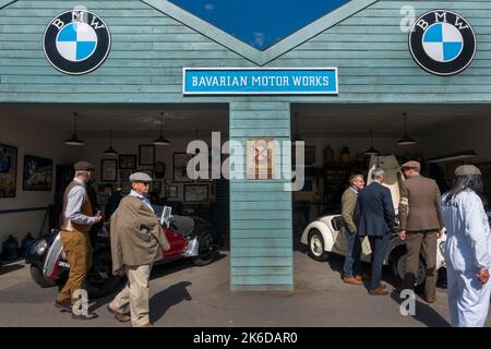 People dressed in vintage period clothes looking at Frazer Nash BMW cars at the Bavarian Motor Works garage, BARC Revival Meeting, Goodwood, UK Stock Photo