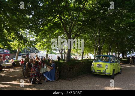 A yellow and blue 1950s Fiat Multipla parked under the trees, BARC Revival Meeting, Goodwood motor racing circuit near Chichester, West Sussex, UK Stock Photo