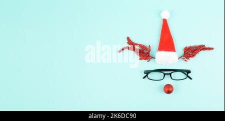 Reindeer with a red bauble nose, antlers, a santa claus hat and eyeglasses, merry christmas greeting card Stock Photo