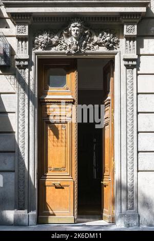 Paris, an old wooden door, with a head carved on the lintel, typical building in the Marais Stock Photo