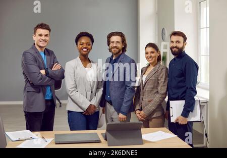 Multiethnic people on board of directors company or corporation stand with smile next to table Stock Photo