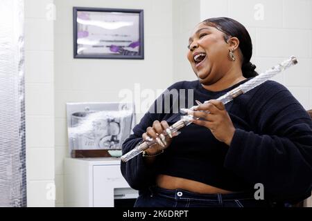 Washington, United States of America. 26 September, 2022. Pop singer and songwriter Lizzo laughs as she tries out a 200-years-old crystal flute during a tour of the Music Division at the Library of Congress, September 26, 2022 in Washington, D.C. The flute once belonged to the fourth President of the United States, James Madison.  Credit: Shawn Miller/Library of Congress/Alamy Live News Stock Photo