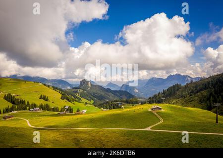 An aerial view of scattered houses on lush green hill under blue cloudy sky Stock Photo