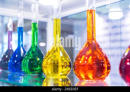 A closeup shot of bottles filled with colorful liquids on the shelves. High quality photo Stock Photo
