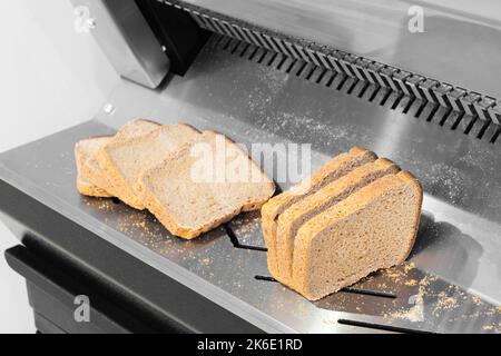https://l450v.alamy.com/450v/2k6e1rd/sliced-bread-in-cutting-machine-industrial-bread-slicer-in-supermarket-with-bread-crumbs-ready-to-use-2k6e1rd.jpg