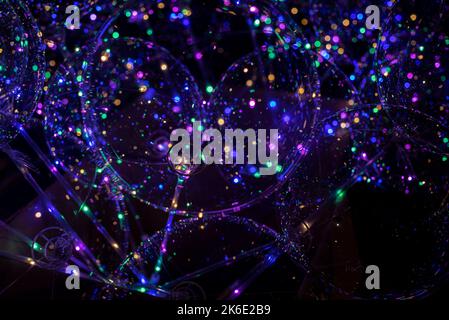 Colorful shining bokeh dots on black background, close up Stock Photo