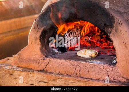 A closeup shot of pieces of wood burning inside old metal oven