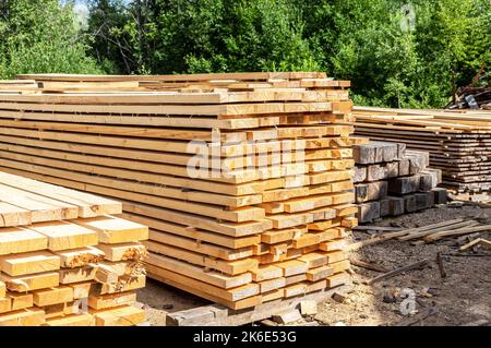 Pile of wooden boards in the sawmill. Warehouse for sawing boards on a sawmill outdoors. Wood timber stack of wooden blanks construction material Stock Photo